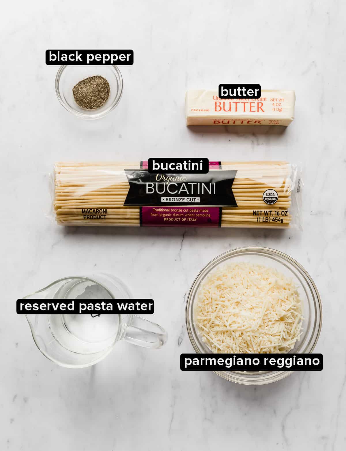 Bucatini Cacio e Pepe ingredients laying on a white background.