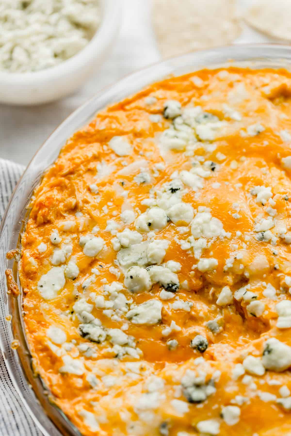 Buffalo Chicken Dip topped with Blue Cheese in a round pie plate.