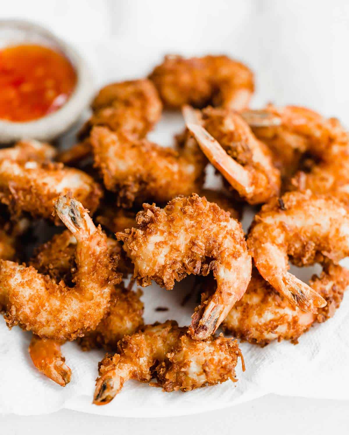 A pile of crispy coconut shrimp on a white plate.