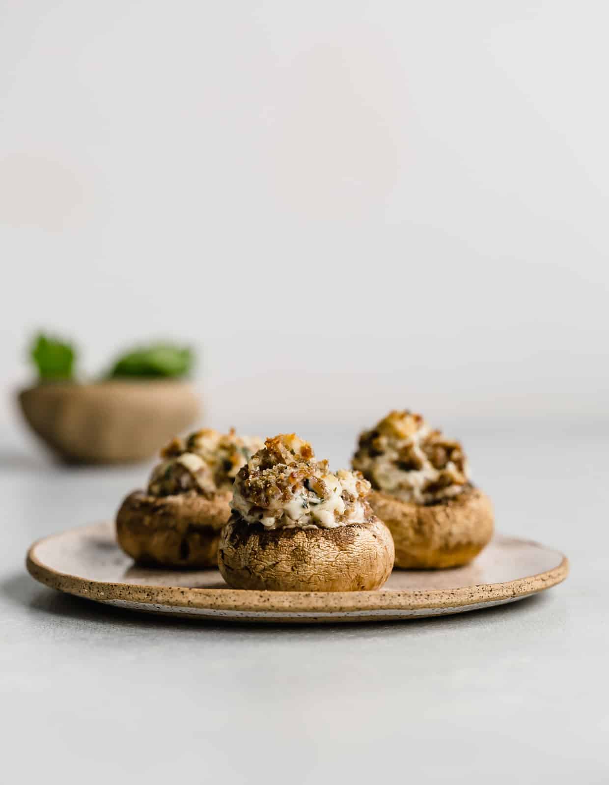 Italian Sausage Stuffed Mushrooms on a plate against a white background.
