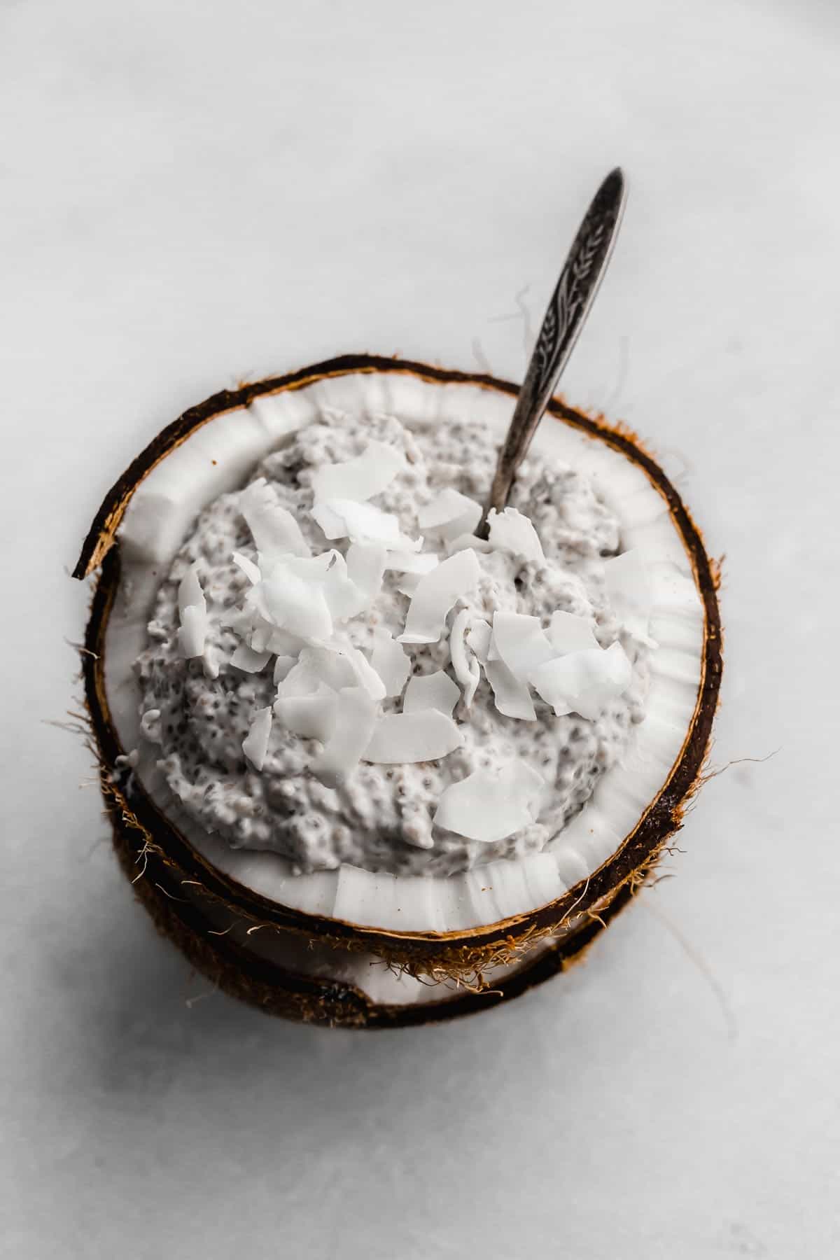 Overnight Coconut Chia Pudding topped with flaky coconut on a white background.