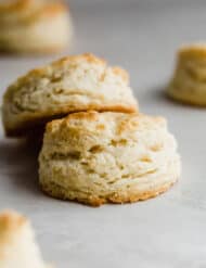 Two easy buttermilk biscuits on a gray background.