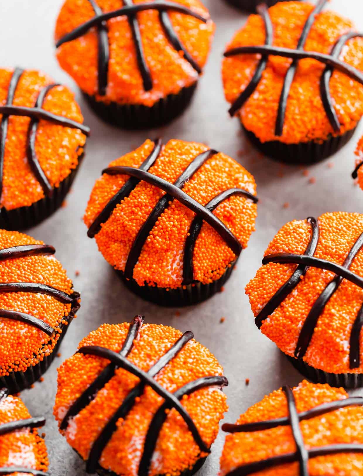 Basketball Cupcakes decorated with small orange spindles and black licorice laces. 