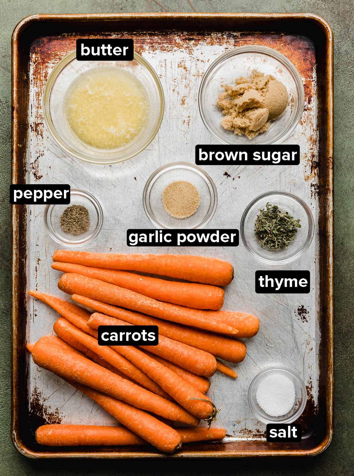 Brown Sugar Roasted Carrots ingredients on a baking sheet.