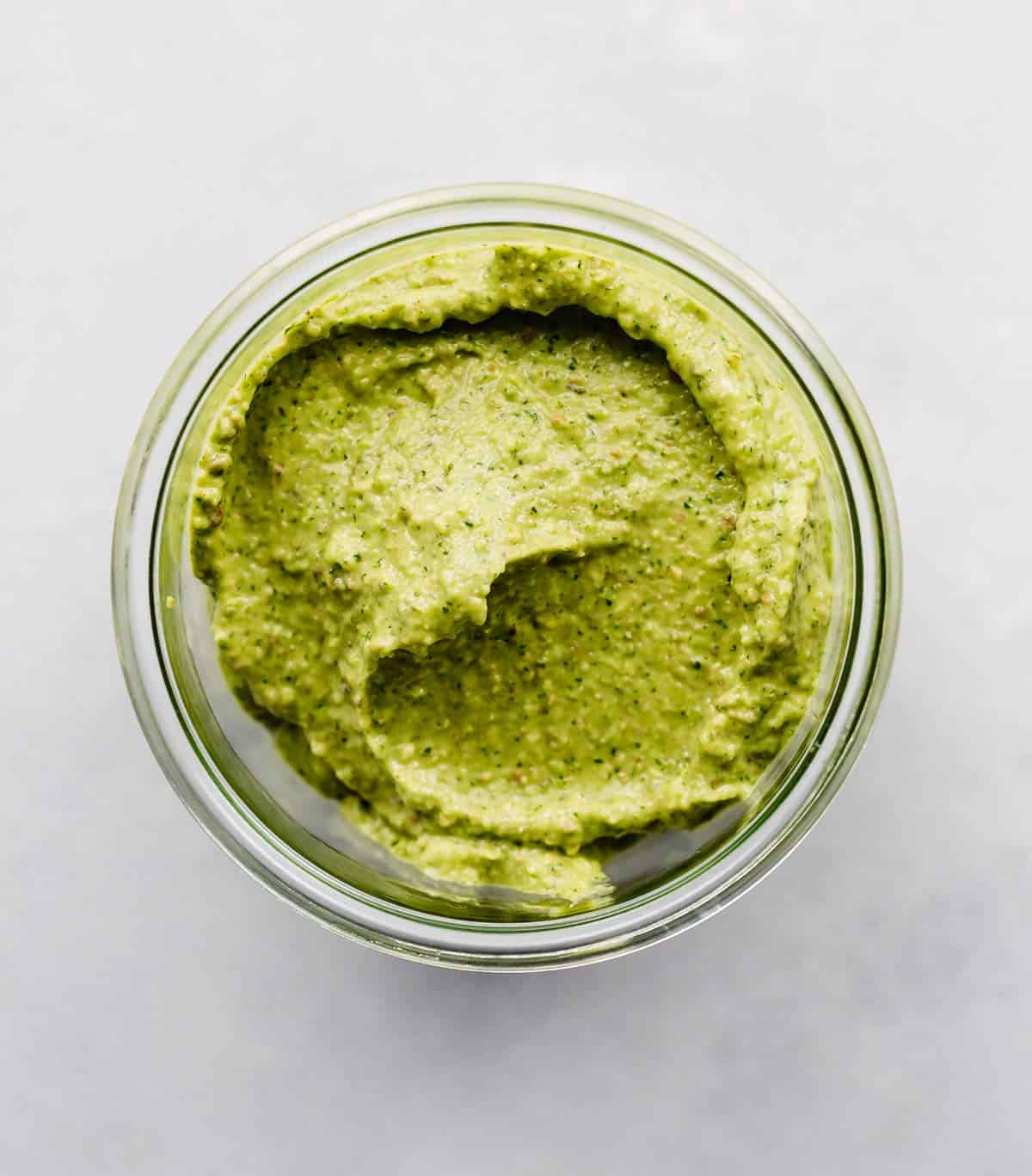 Green Sauce in a glass cup on a white background.