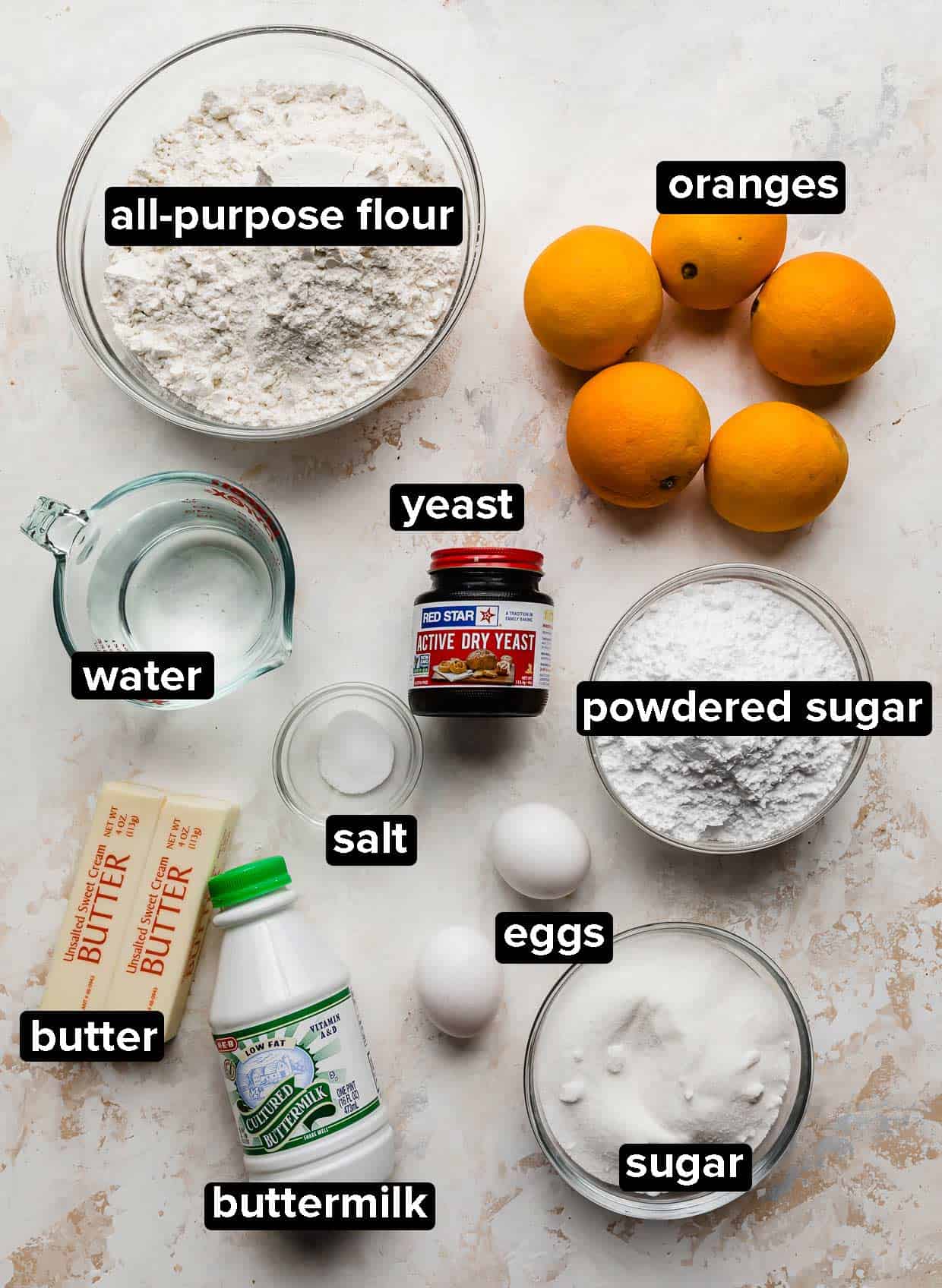 Orange Rolls recipe ingredients on a white and cream textured background.