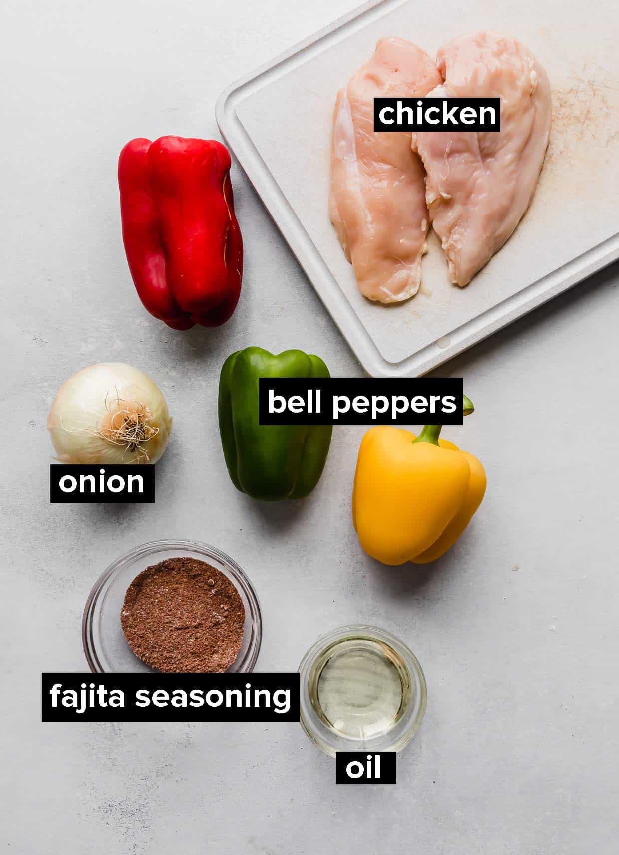 Ingredients used to make sheet pan chicken fajitas on a light background.