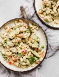 A macaroni salad loaded with vegetables on a plate.