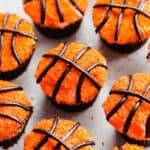Basketball Cupcakes decorated with orange sprinkles and black licorice laces.