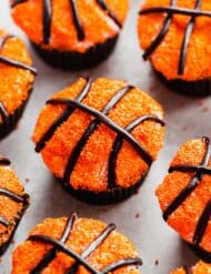 Basketball Cupcakes decorated with orange sprinkles and black licorice laces.