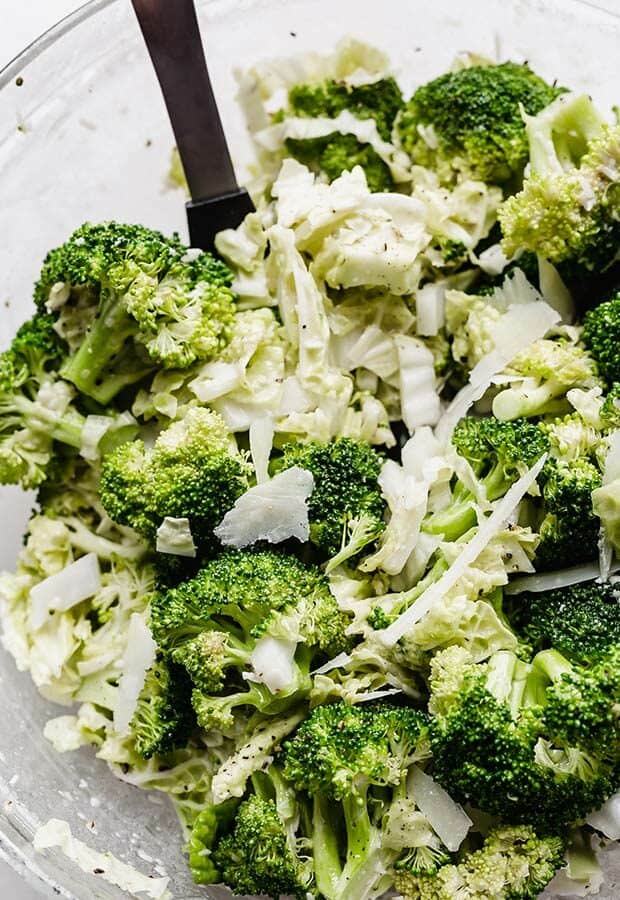 A close up photo of broccoli florets and sliced cabbage in a bowl.