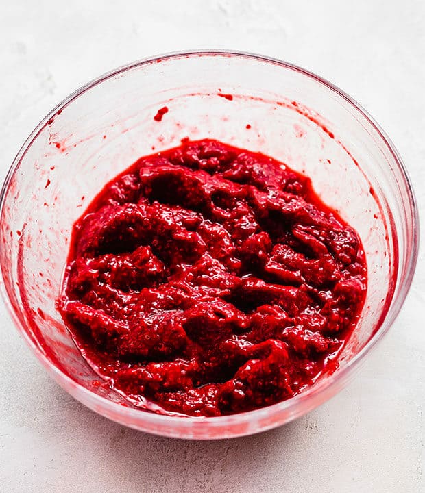 Mashed raspberries in a bowl.