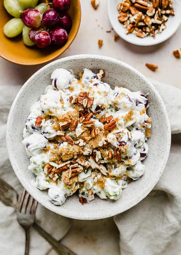 Overhead photo of creamy grape salad topped with brown sugar and chopped pecans.