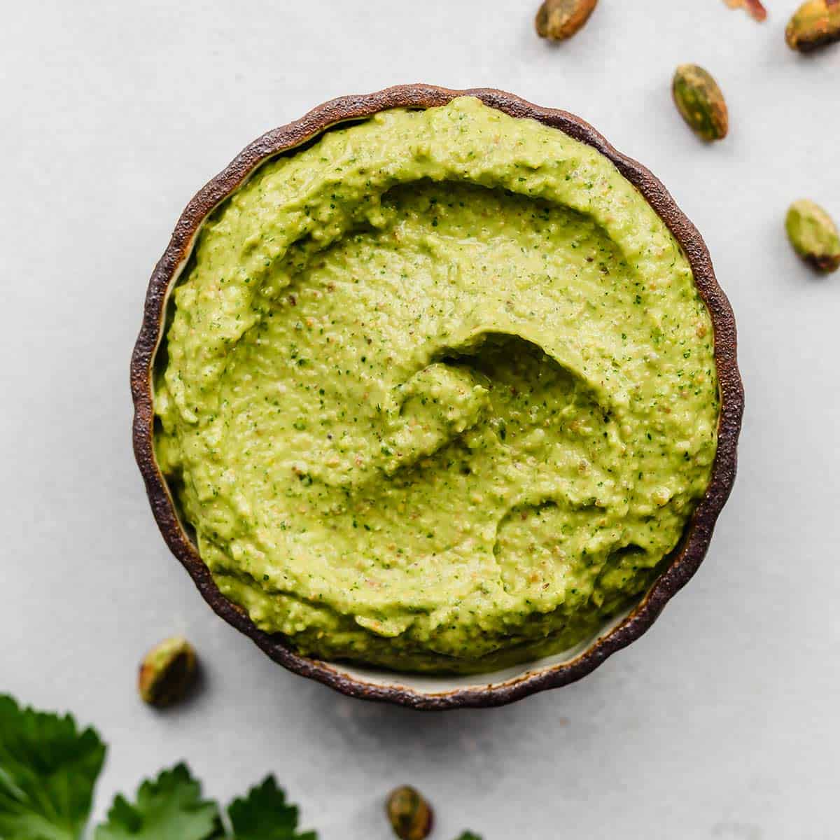 A black rimmed bowl filled with a vibrant Green Sauce Recipe in it.