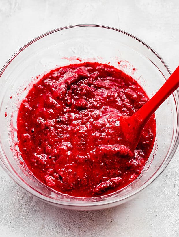 Overhead photo of mashed raspberries in a bowl.