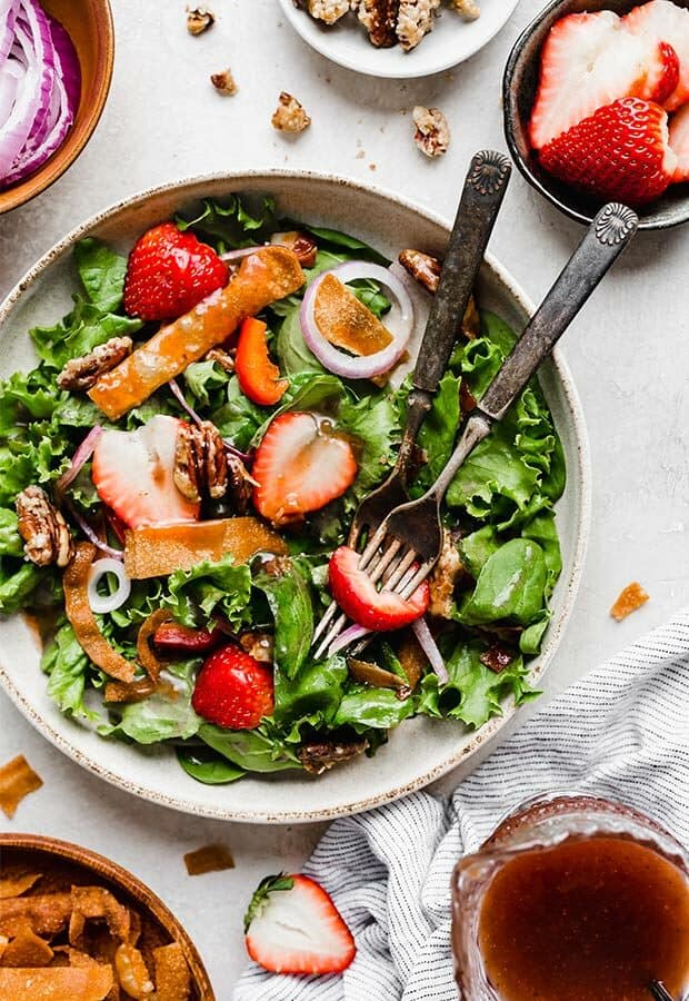 Two forks in a bowl of Strawberry Spinach Salad.