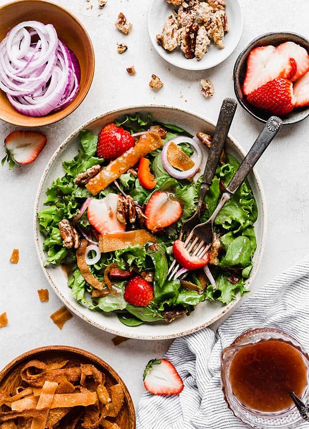 Overhead photo of a strawberry spinach salad topped with a homemade strawberry salad dressing.