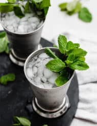 A virgin mint julep in a silver cup with a sprig of mint.