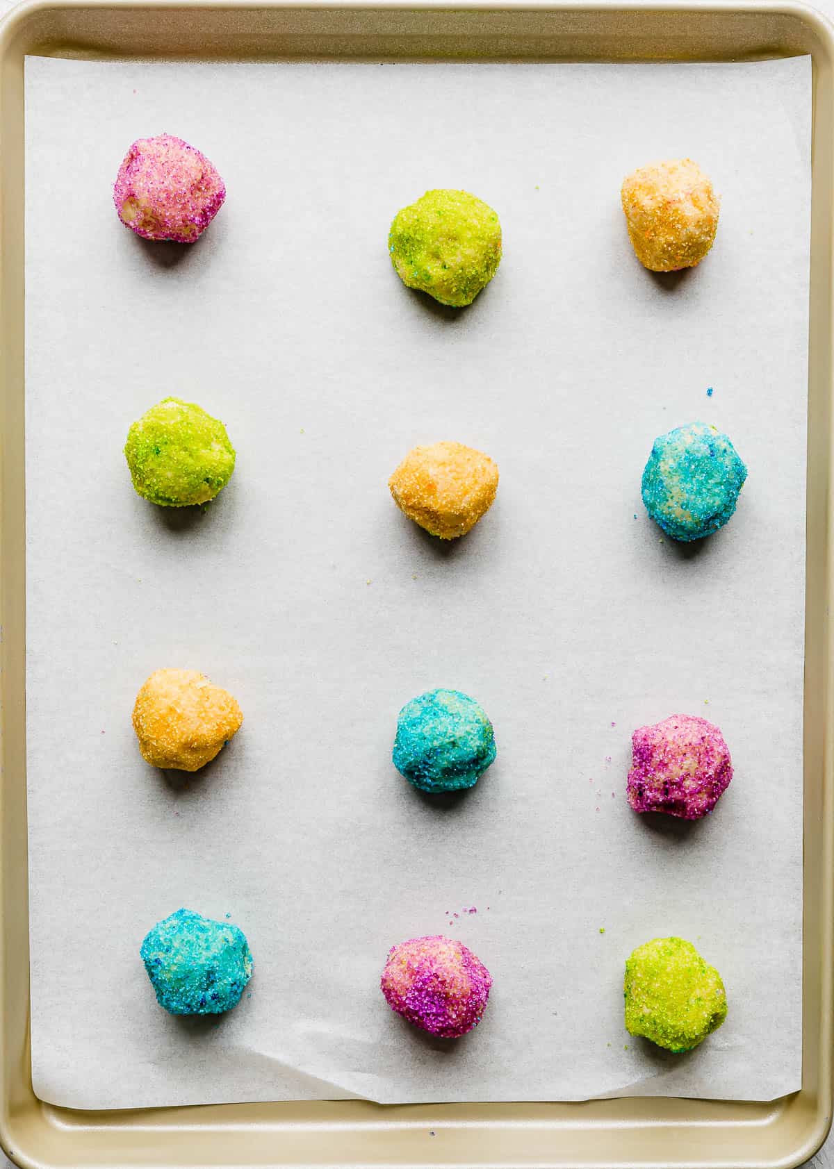 Cookie dough balls covered in colored sugar or fine sprinkles.