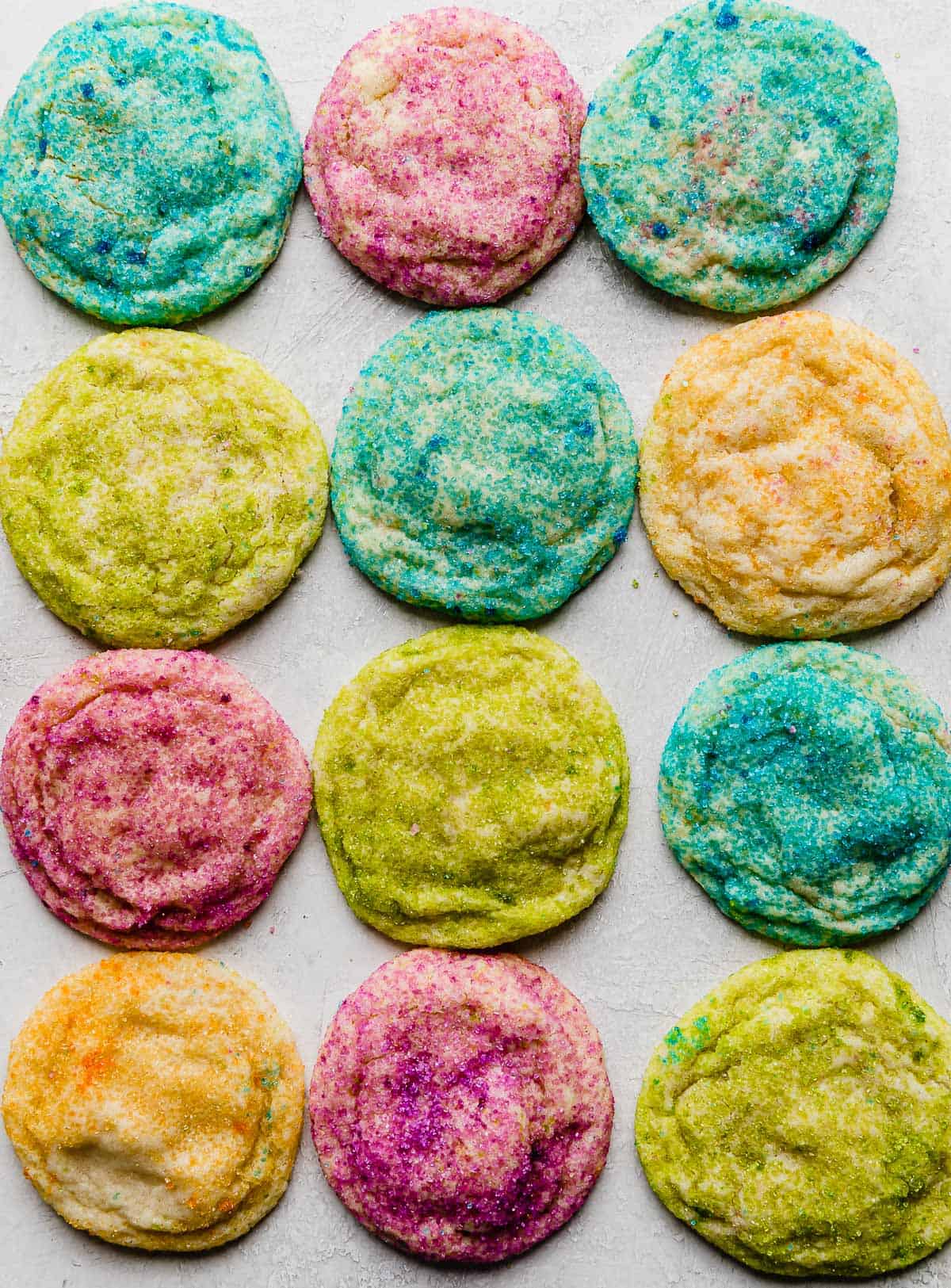 Sugar cookies covered in colorful sugar on a white background.