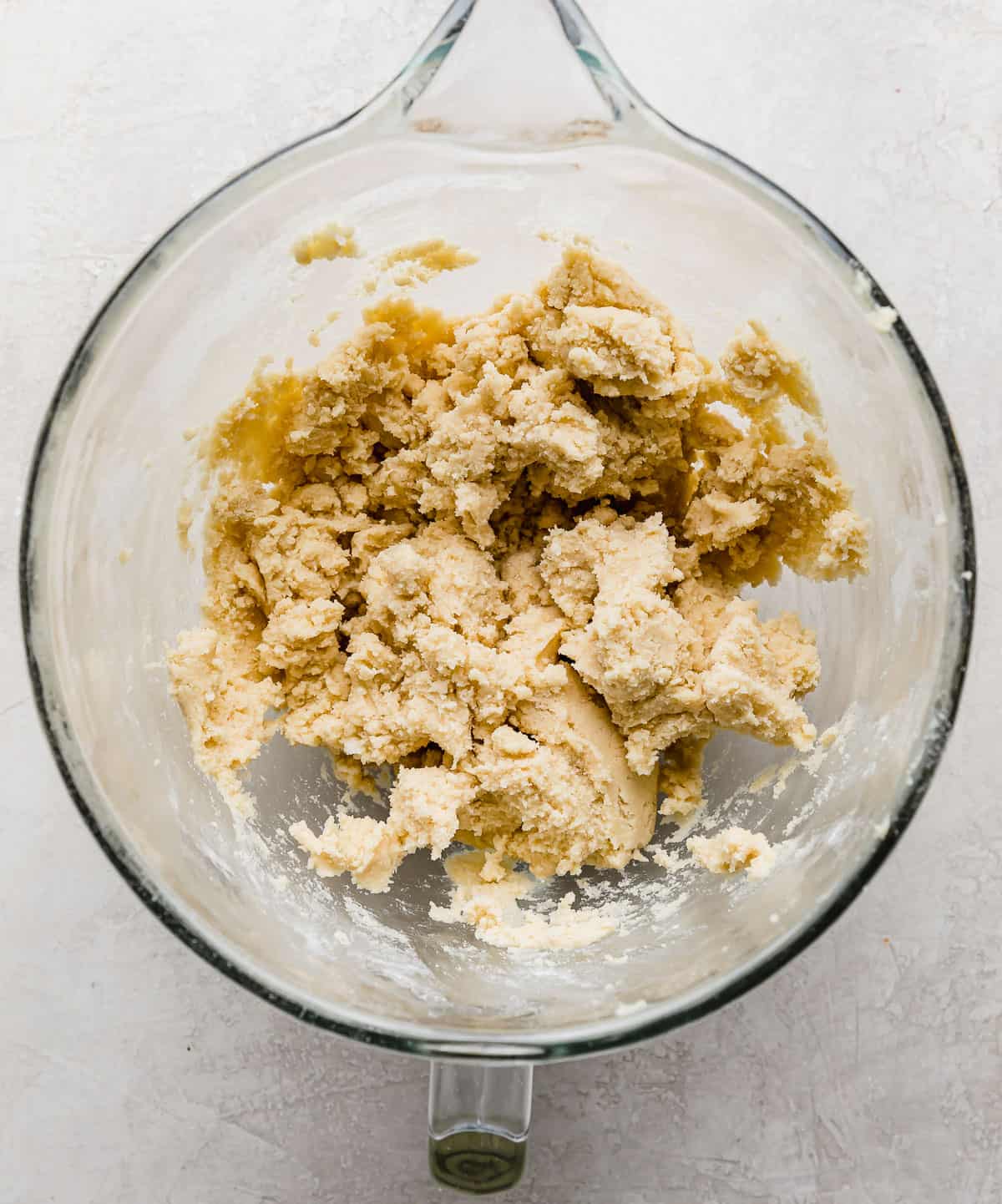 Sugar cookie dough made in one bowl, on a gray background.