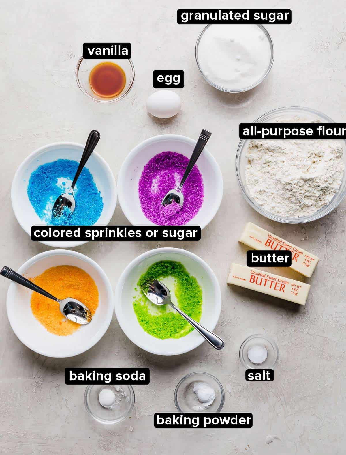 Ingredients used to make sugar coated cookies on a light gray background.