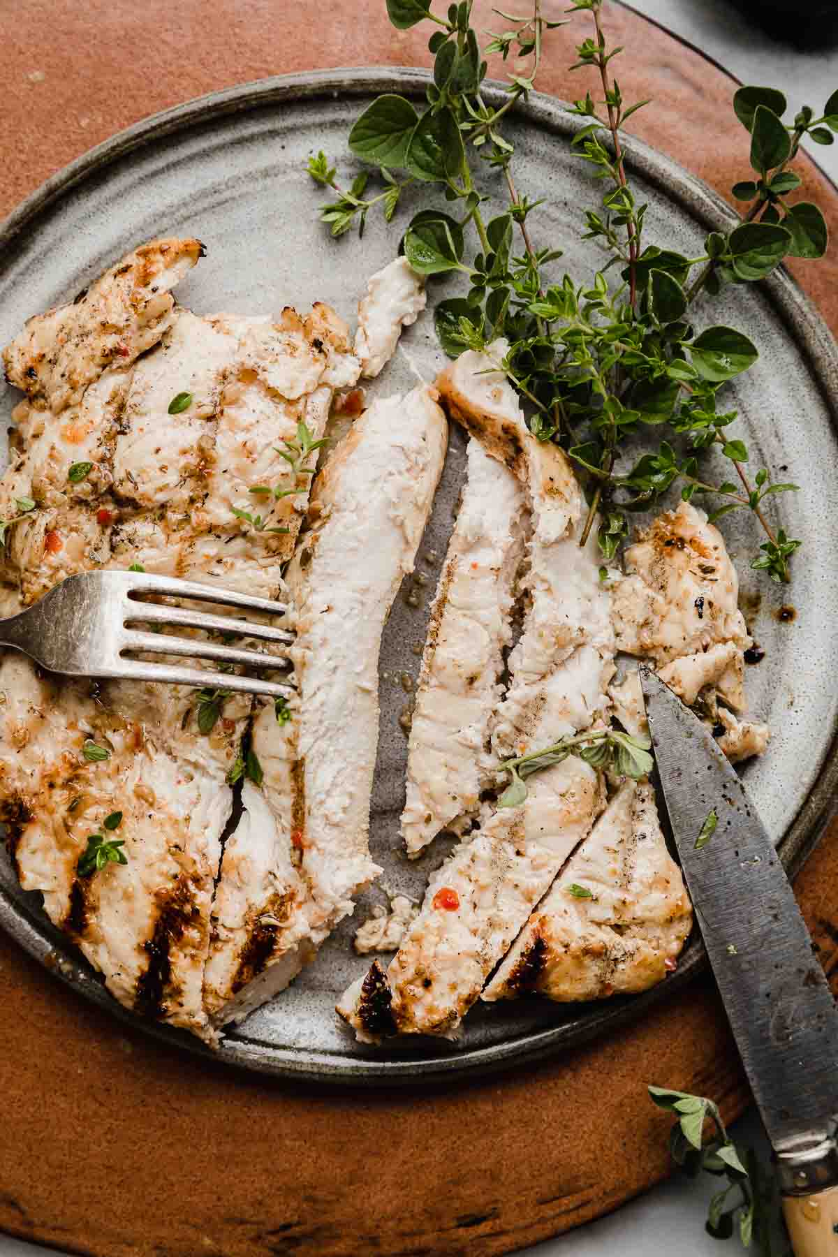 Italian Grilled Chicken sliced into strips, on a gray plate.