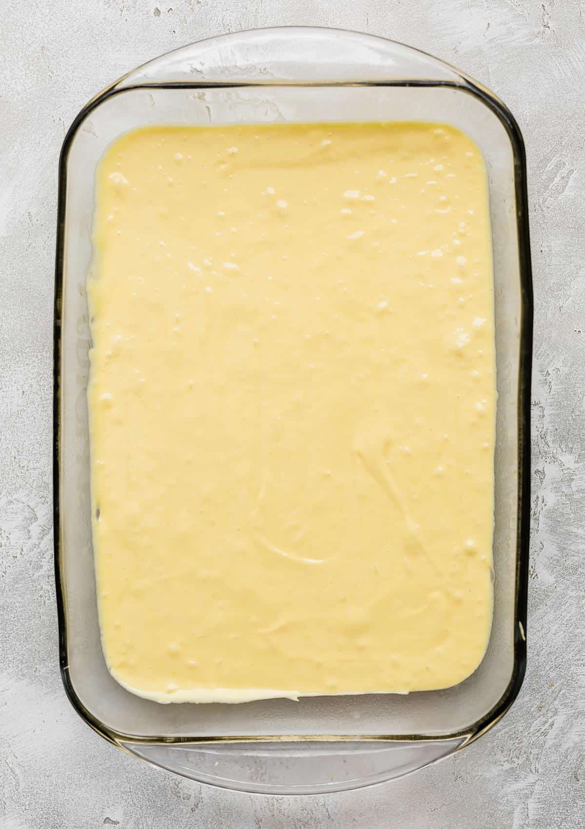 Lemon cake batter in a rectangular glass baking dish.