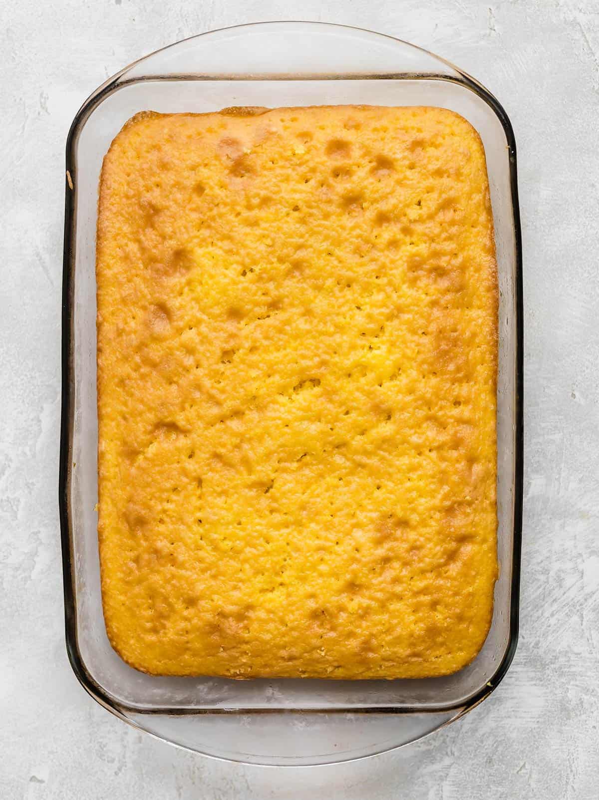 A baked lemon cake in a rectangular glass pan.