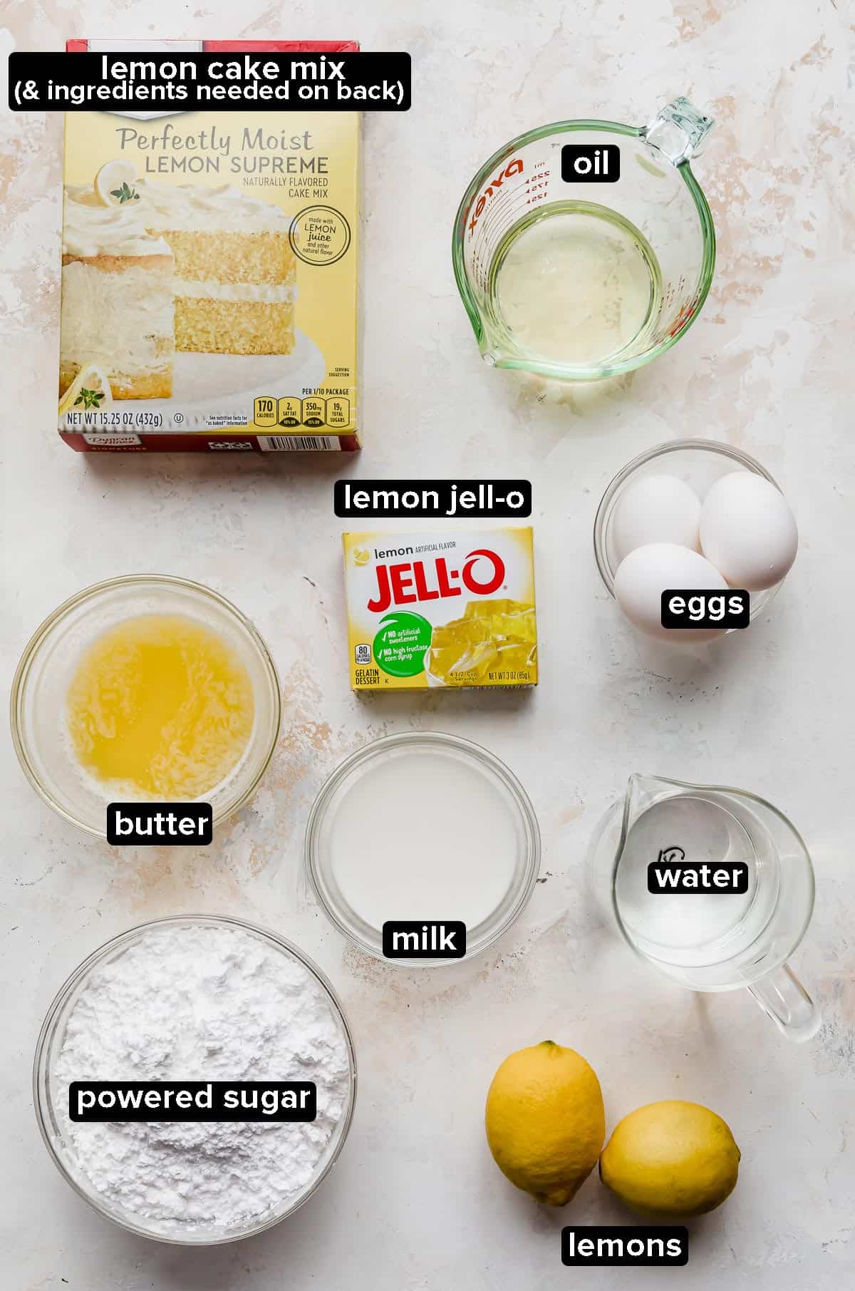 Lemon Jello Cake ingredients on a white textured background. 