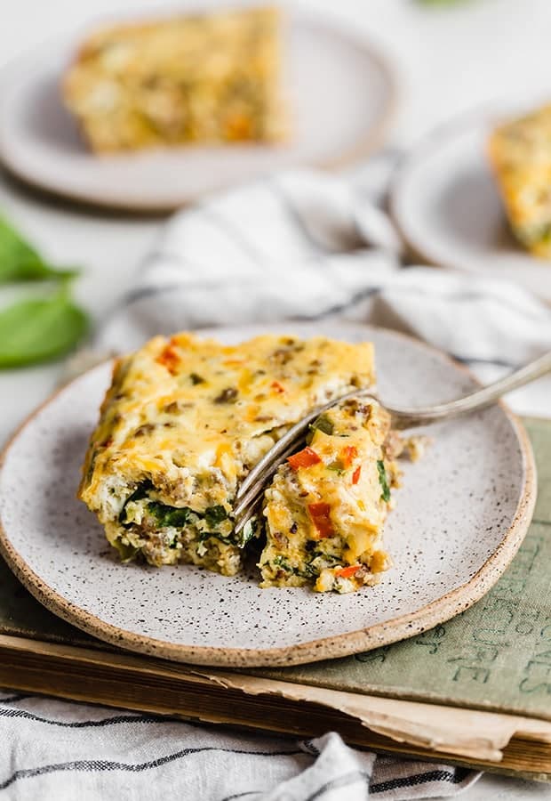 A fork cutting into a slice of breakfast casserole.