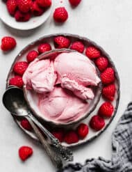 Overhead photo of Raspberry Ice Cream in a bowl surrounded by fresh raspberries.