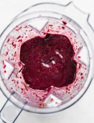 Overhead photo of Acai Smoothie in a blender on a white background.