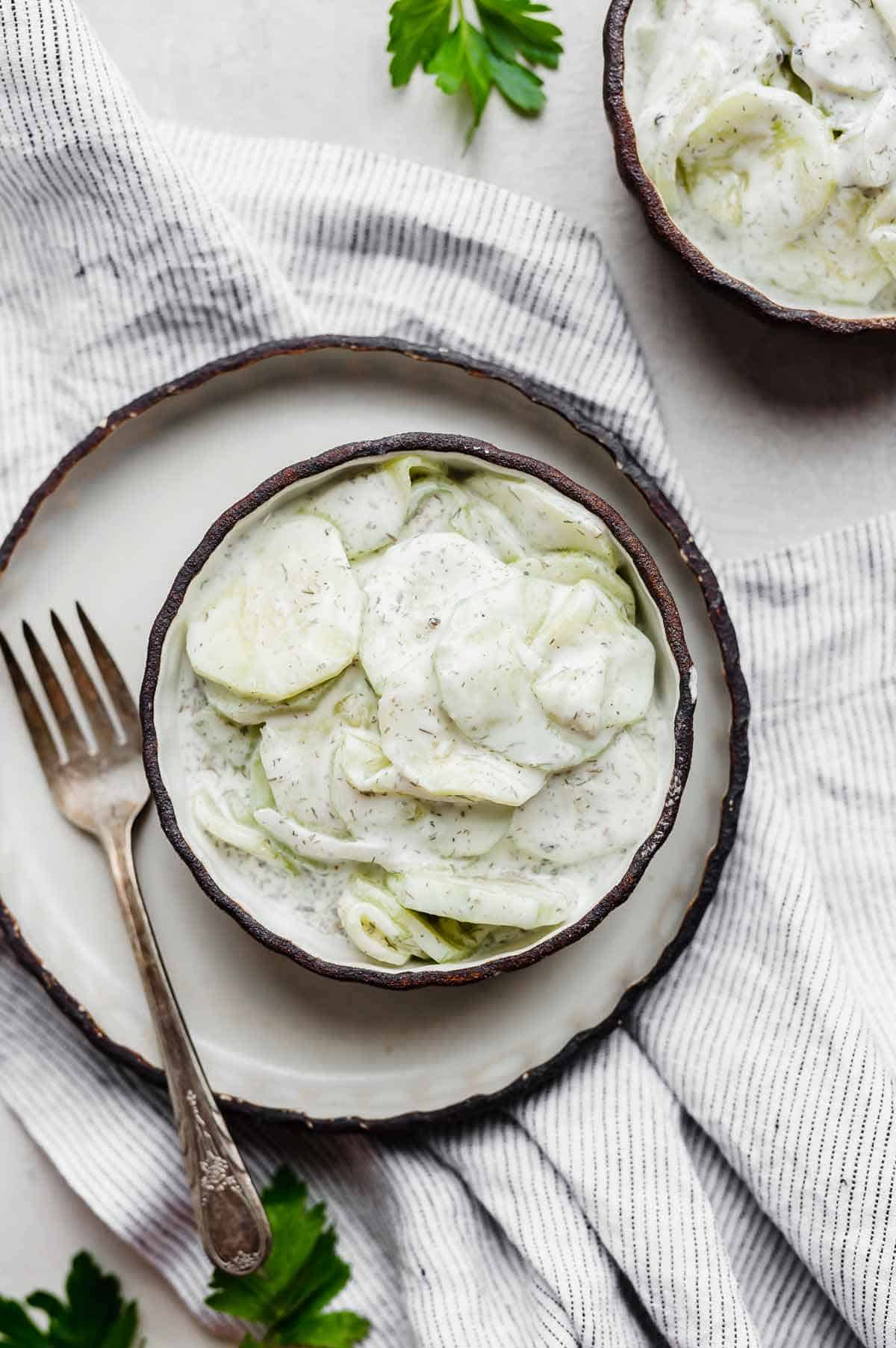 A round bowl with a Creamy Cucumber Salad in it.