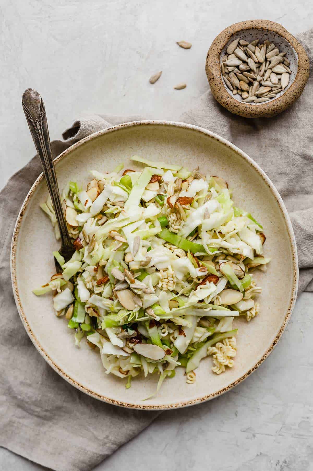 Crunchy Cabbage Salad in a tan pasta bowl on a gray background.