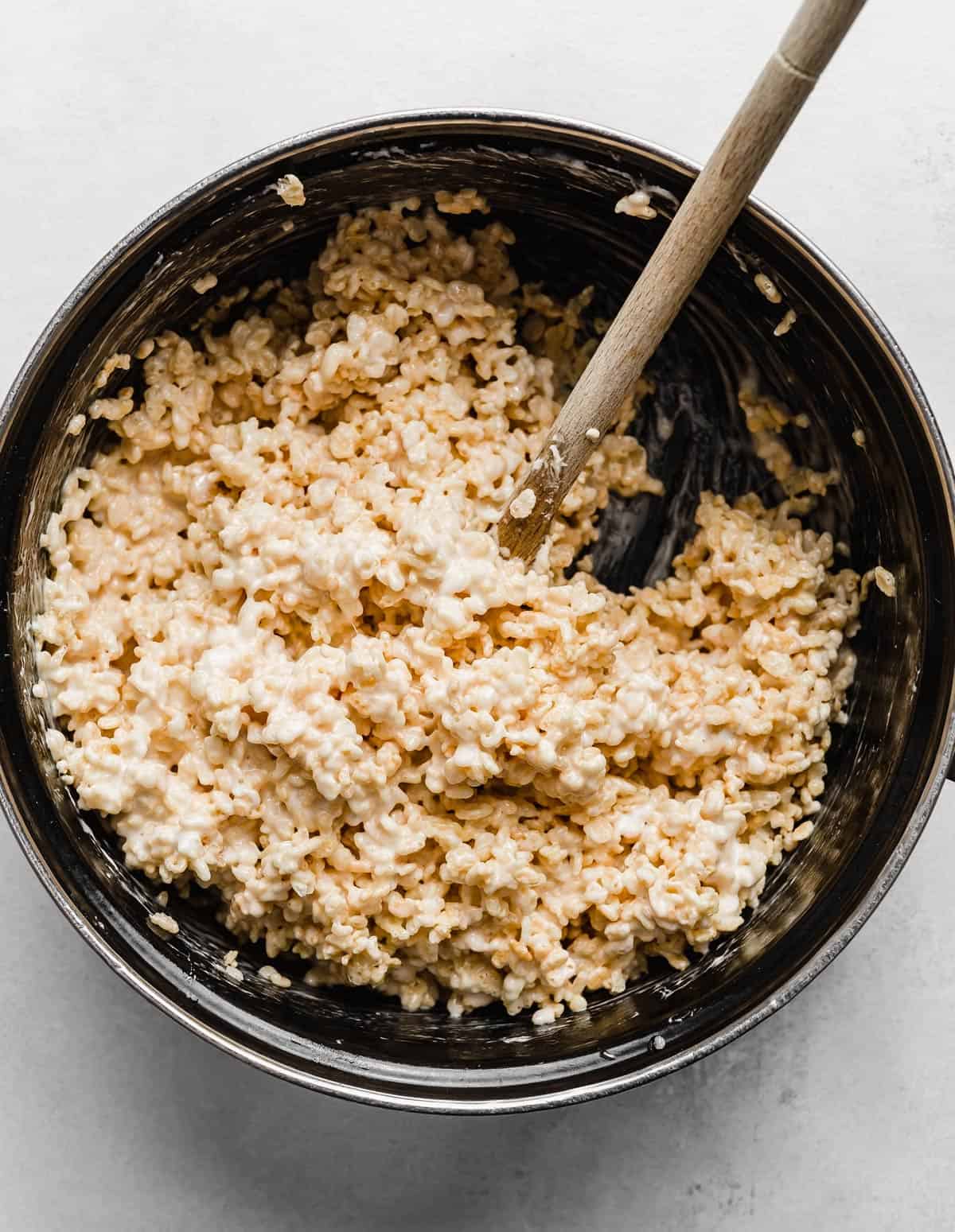Gooey Rice Krispies Treats being stirred together in a large black pot.