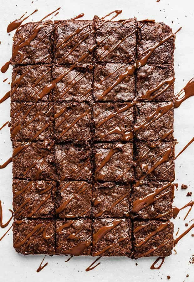 Overhead photo of brownies cut into squares and topped with a drizzle of chocolate sauce.