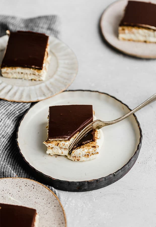 A fork cutting into a square slice of Chocolate Eclair Cake.