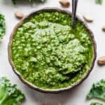 A bright green Kale Pesto made with pistachios and kale in a bowl.