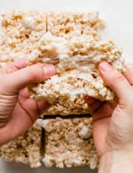 Two hands pulling a homemade Rice Krispies Treats apart.
