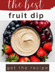 Tan colored fruit dip in a black bowl surrounded by colorful fruit with the word, "the best fruit dip" written above the photo.