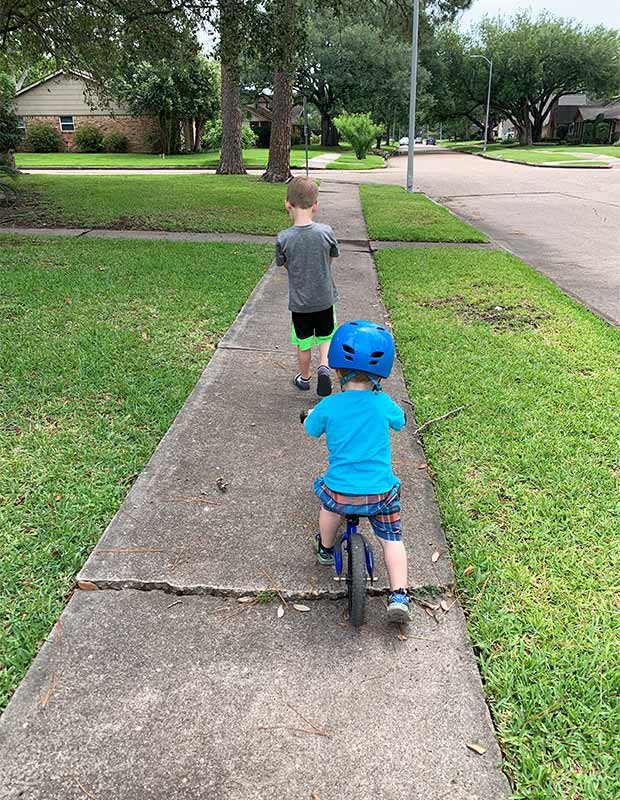 Two boys on a sidewalk.