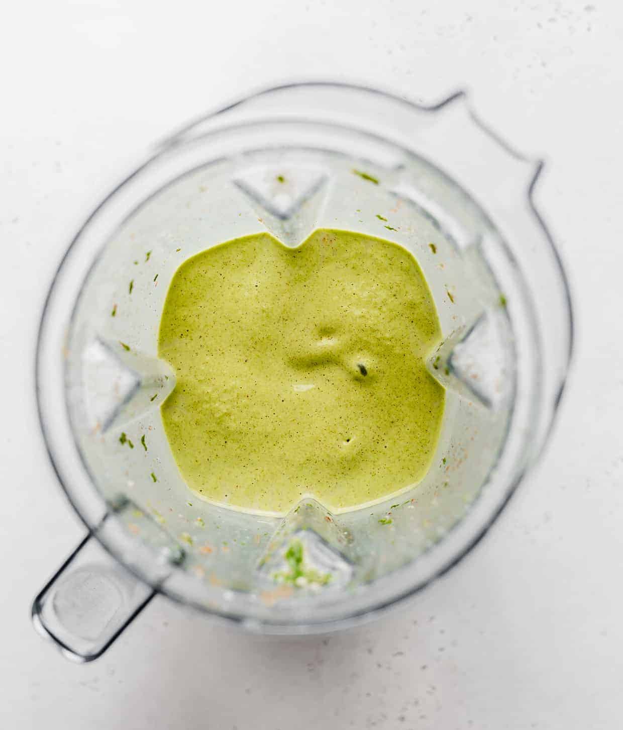 A pureed healthy green smoothie in a blender.