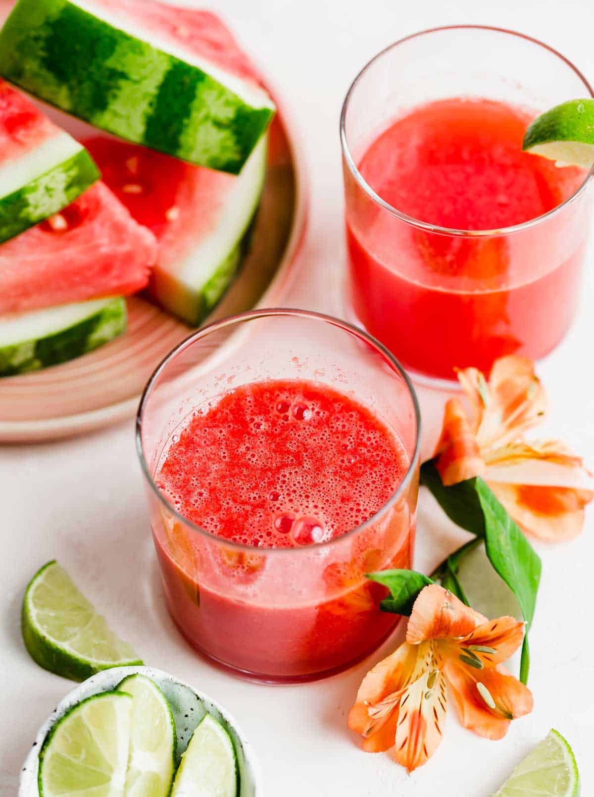 Watermelon Juice in glass cups on a light peach colored background.