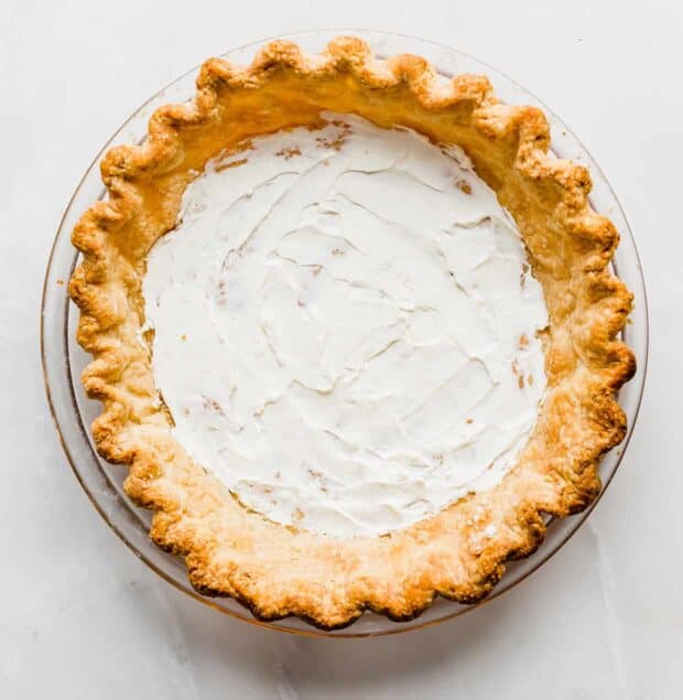 An all-butter pie crust with a smear of cream cheese along the bottom of the crust.