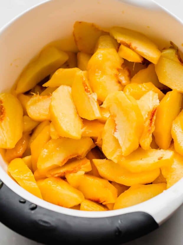 peeled and sliced peaches in a bowl.
