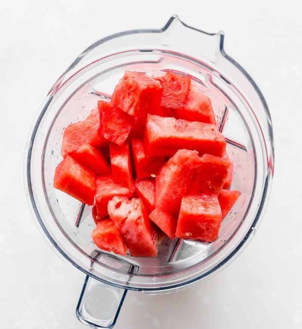 A blender with cubed watermelon in it.
