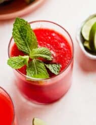 Watermelon Juice in a glass cup with a mint leaf for garnish.