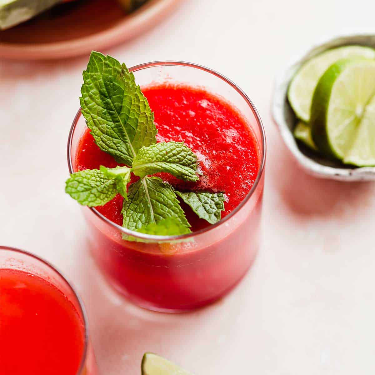 Watermelon Juice in a glass cup with a mint leaf for garnish.
