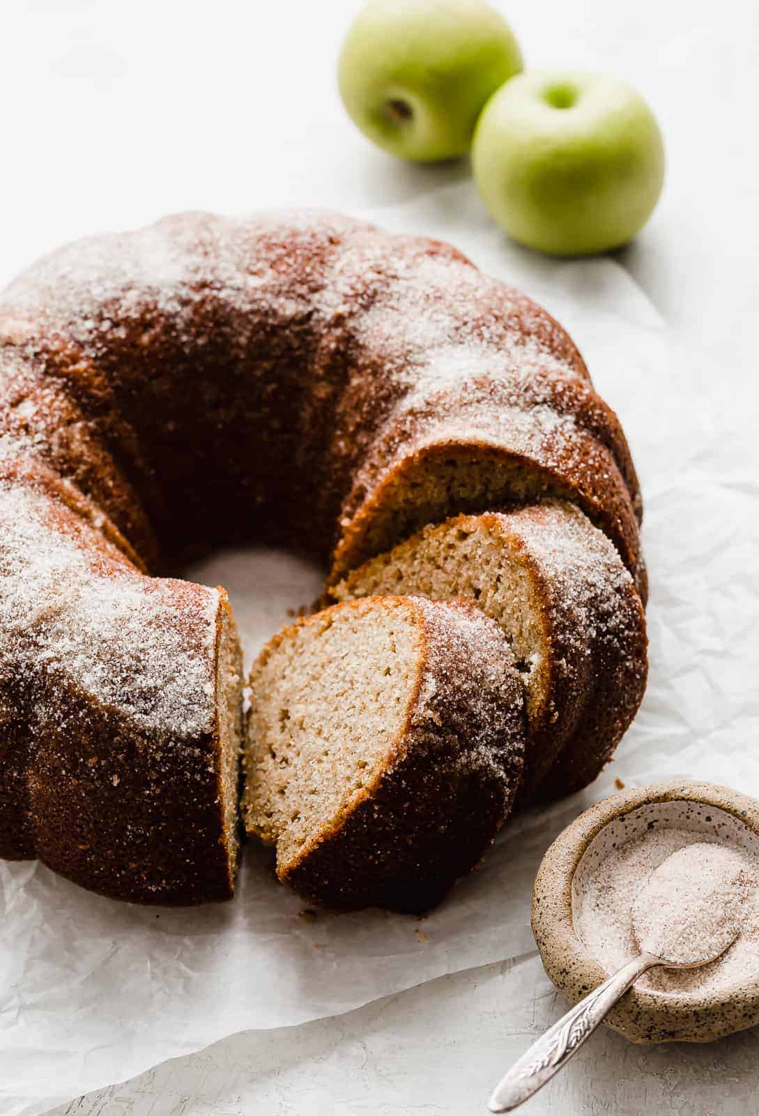 An apple cider cake with cinnamon sugar sprinkled overtop.